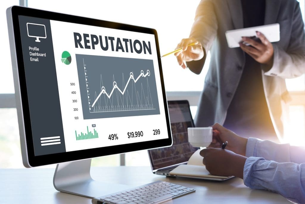 People looking at a computer screen with the word reputation on it.