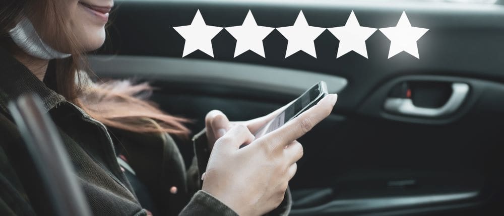 A person in a car leaving an online review for a business.