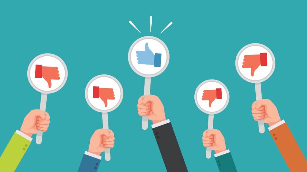 Hands holding signs that show negative social media reactions.