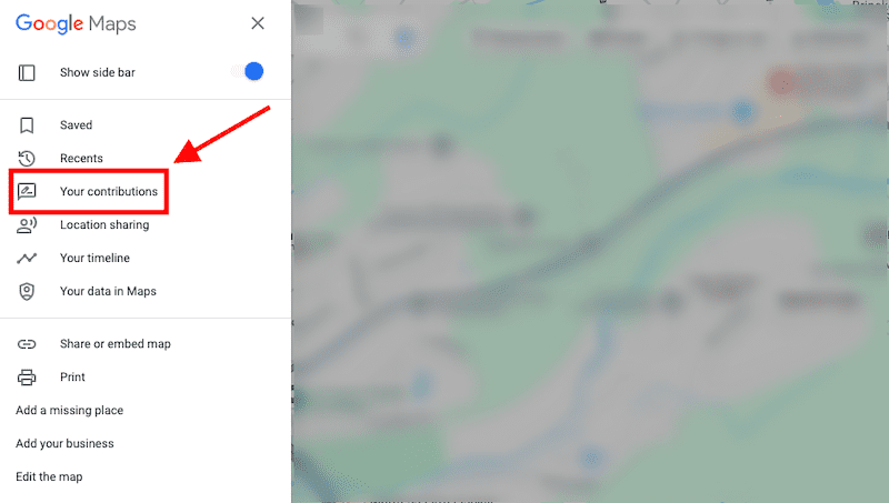 A screenshot of Google Maps with a red arrow pointing to the "Your contributions" tab in the side menu. The background shows a blurred map view.